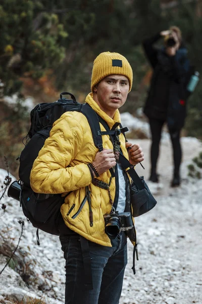 Retrato de hombre joven en ropa de abrigo en el bosque de invierno bebiendo  té caliente al aire libre del termo senderismo turismo