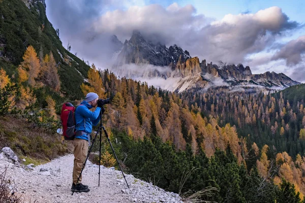 イタリアのアルプスやドロマイトの山々を背景にしたカラフルなジャケット姿の男性旅行者は 日没時 高イソのイメージ — ストック写真