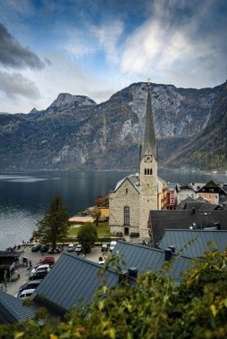 Hallstatt şehir merkezi Evanjelik Kilisesi manzaralı, eski kasaba evleri, Hallstatter Gölü ve Alpler seti arka planda, Salzkammergut, Avusturya.