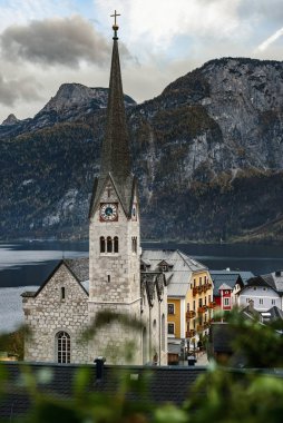Hallstatt şehir merkezi Evanjelik Kilisesi manzaralı, eski kasaba evleri, Hallstatter Gölü ve Alpler seti arka planda, Salzkammergut, Avusturya.