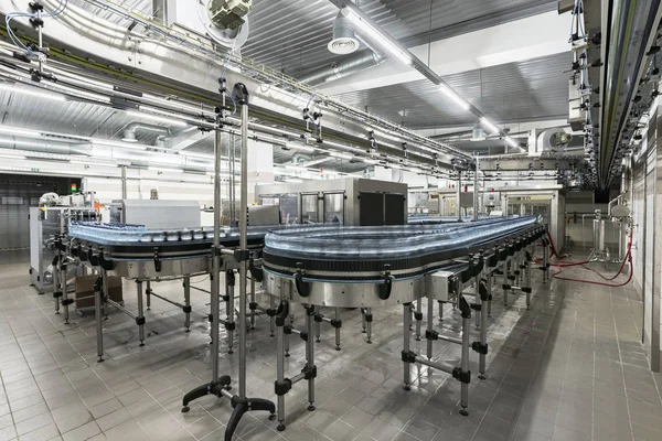 Fabrikada su bulunan plastik şişelerle modern üretim hattı.