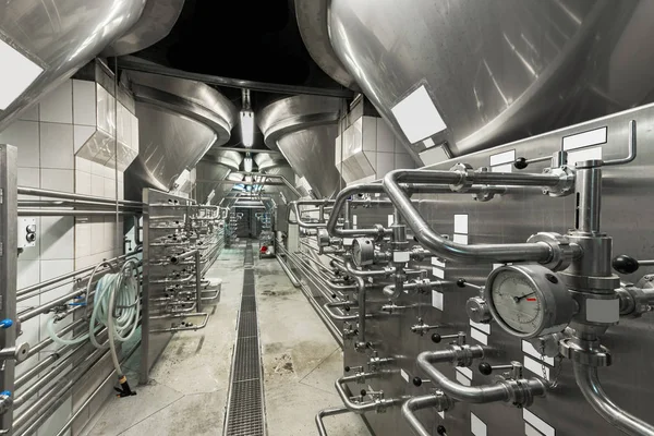 Close Up Of Modern Beer Factory. Rows of steel tanks for beer fermentation and maturation. (high iso image)