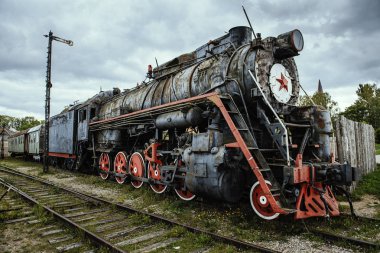 Dramatik bulut arkaplanlı eski bir buhar treni lokomotifi.