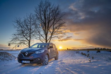Jelgava, Letonya / 03.14.2020: Mavi Renault Kadjar SUv arabası gün batımında karda