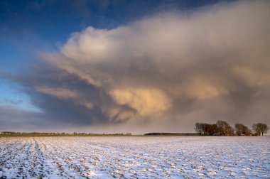 Gün batımında pembe kar fırtınası bulutu oluşumu, önplanda büyük kar örtüsü.
