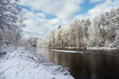 Baltık devletlerinde Gauja nehri kışın derin kar ve mavi gökyüzüyle. 