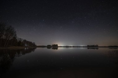 Geceleri manzara, göl üzerinde yıldızlarla dolu gökyüzü (yüksek ISO fotoğrafçılığı)