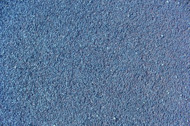 Spor sahası dokusunda mavi yumuşak plastik granüller. Çalışan kauçuk kapağın dokusu