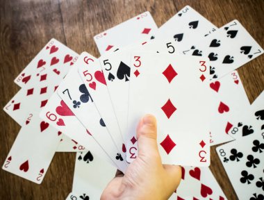 Kağıt oynuyorum. Çocukların elinde kumar kartları var. Çocukluk konsepti - boş zaman, eğlence ve hobi. Poker kartı arkaplanı. 