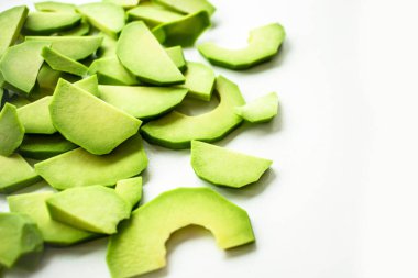 Beyaz arka planda bir sürü avokado dilimi var.