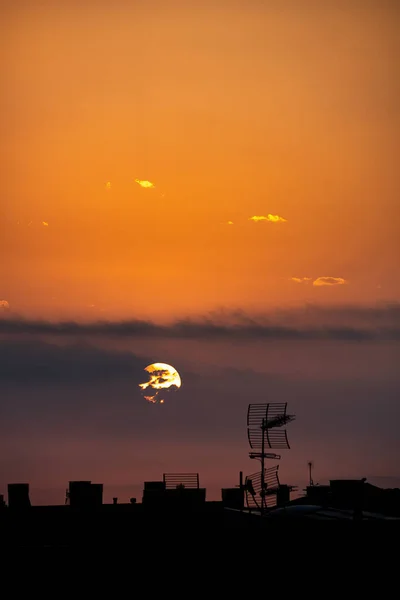 Солнце появляется из-за облаков, над городом, вид сверху на крышу . — стоковое фото