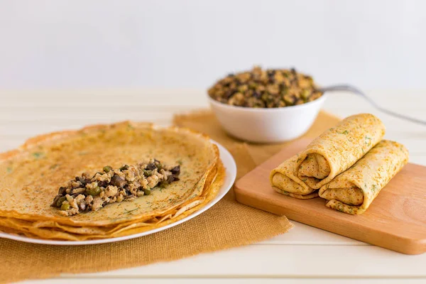 Delgados panqueques sabrosos con rellenos. Crepes rellenos con champiñones picados de carne de pollo y pepino marinado . — Foto de Stock