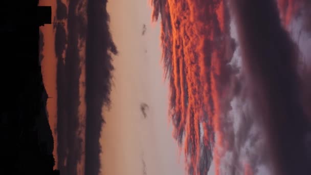 Timelapse of sunset afterglow, illuminating clouds at dusk moving to different sides -Vertical Shot- — Stock Video