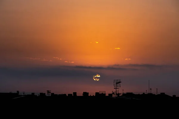 El sol aparece detrás de las nubes, por encima de la ciudad, vista de la azotea . —  Fotos de Stock