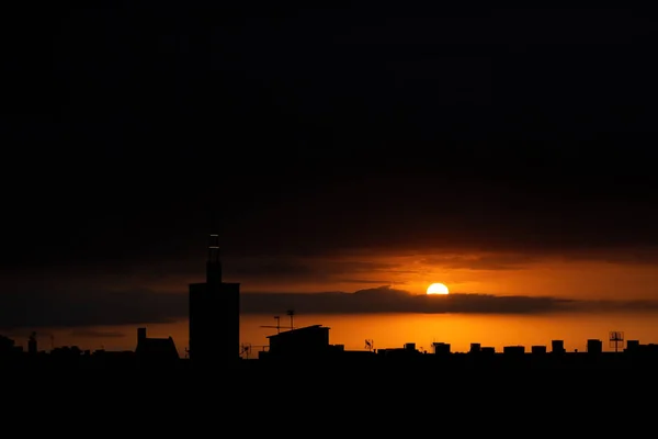 Zon verschijnt van achter de wolken, uitzicht op het dak van een oude kerktoren. — Stockfoto