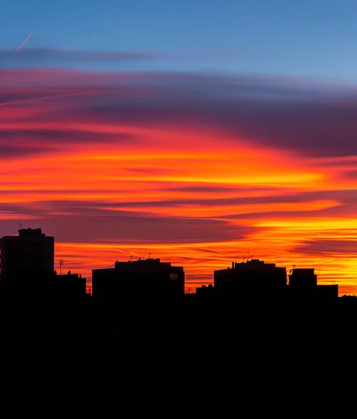 迷人的日落，橙色、粉色和红色的云彩笼罩着这个城市。 预测和气象学概念的背景 — 图库照片