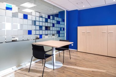 Modern ofis içinde masa ve sandalyeli boş sohbet odası.