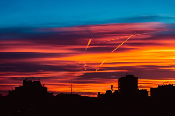 迷人的日落，橙色、粉色和红色的云彩笼罩着这个城市。 预测和气象学概念的背景 — 图库照片