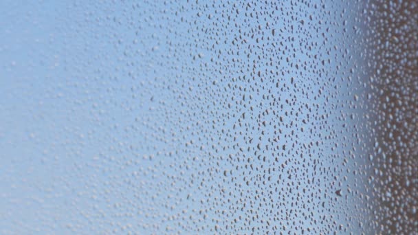 Misted glass of window with water drops texture and blue background. Selective focus. — Stockvideo