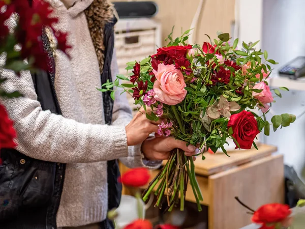 Florista faz belo buquê de rosas mistas e outras flores em uma loja. Flores frescas cortadas — Fotografia de Stock