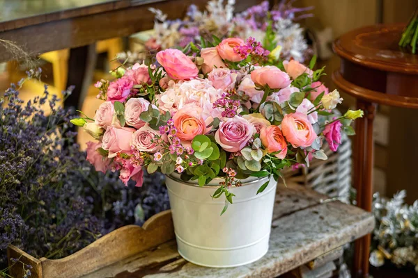 Belo buquê multicolorido de rosas mistas e outras flores em uma loja. Flores frescas cortadas colocadas em vaso de flores brancas — Fotografia de Stock
