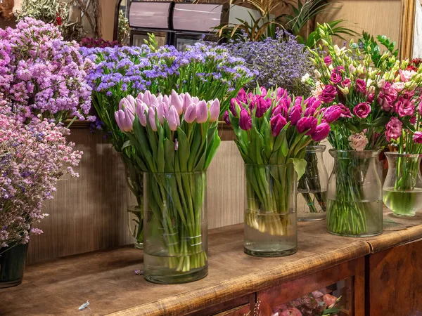 Lindas flores coloridas para venda, colocadas em vasos na loja de flores. Tulipas, rosas e limonium — Fotografia de Stock