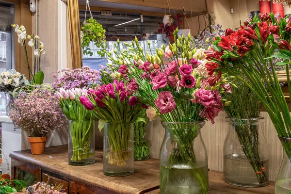 Variedade de belas flores na loja à venda, colocadas em vasos na loja de flores. Tulipas, rosas e limonium — Fotografia de Stock