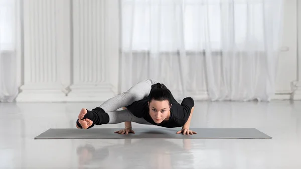 Ung asiatisk kvinna i yoga klass gör asana övningar. Flicka gör åtta vinklar Pose. Hälsosam livsstil i fitness club. Balansställning. — Stockfoto