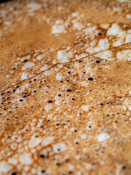 Close-up de pequenos buracos durante as panquecas de fritura na frigideira de ferro. Cozinhar em casa com crepes de aberturas deliciosas. Foco seletivo . — Fotografia de Stock