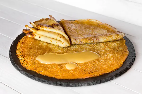 Crepes caseiros blini e mel sobre fundo branco de madeira, vista lateral. Panquecas finas para pequeno-almoço ou sobremesa . — Fotografia de Stock