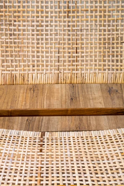 Detail of modern wicker chair standing on laminate. Interior wooden furniture.