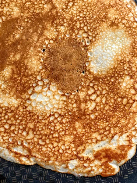 Making delicious openwork pancake on iron frying pan. Home cooking. Close-up top view — Stock Photo, Image