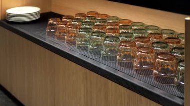 Su, meyve suyu ve beyaz tabaklar için şeffaf içme bardakları olan bir bar veya restoranın yan tahtası