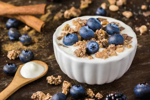 Joghurt mit frischen Blaubeeren auf Holztisch — Stockfoto