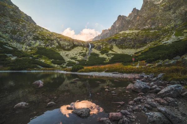 Lago de montaña con rocas en primer plano al atardecer — Foto de Stock