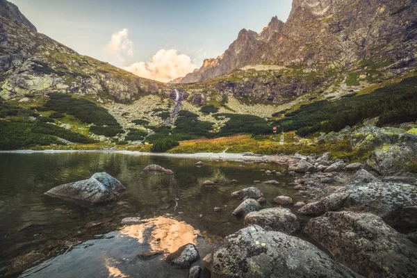 Hegyi tó sziklák, előtérben a naplemente — Stock Fotó