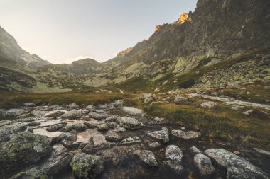 Gün batımında dağ zirveleri altında Vadisi'nde Creek