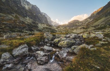 Gün batımında dağ zirveleri altında Vadisi'nde Creek