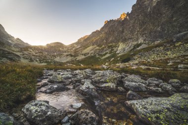 Gün batımında dağ zirveleri altında Vadisi'nde Creek