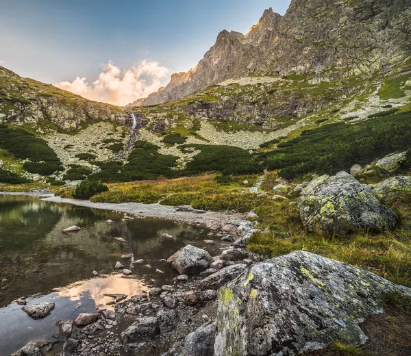 Lago de montaña con rocas en primer plano al atardecer —  Fotos de Stock