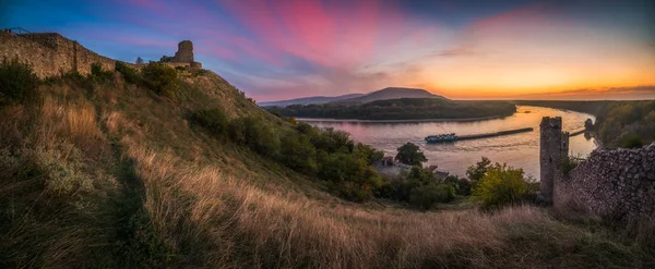 Ruine auf einem Hügel über einem Fluss bei Sonnenuntergang — Stockfoto