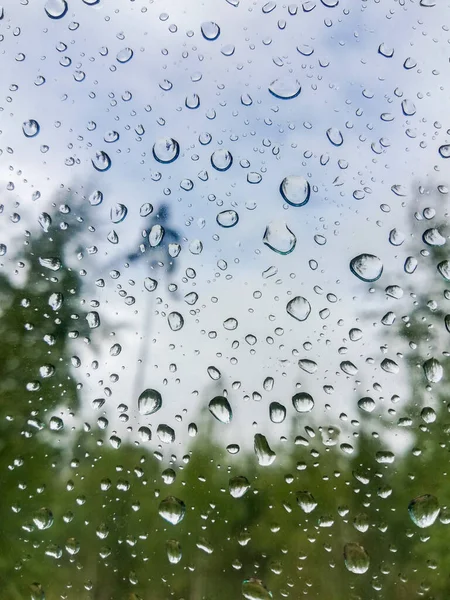 Mavi gökyüzüne karşı camına yağmur damlaları