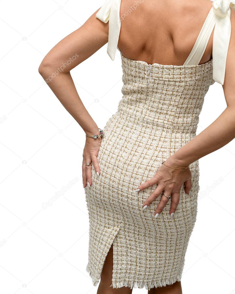 The girl stands with her back, clasping her hips, in a tight dress. A sexy figure. On white background.