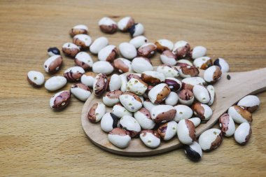 Ahşap arka planda böcekler tarafından yenen kurutulmuş kayısı. Delinmiş Fasulye.