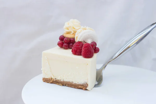 クリームチーズのフリストリング ラズベリー クランベリー マカロン 白いケーキスタンドのカップケーキとバニラニューヨークチーズケーキのピース — ストック写真