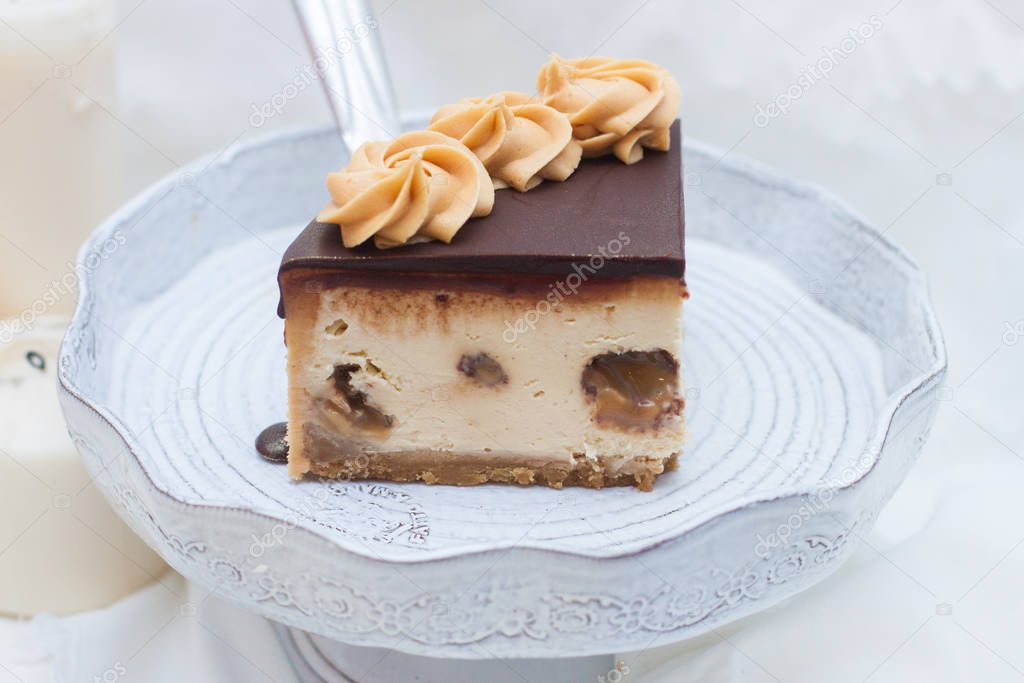 Piece of peanut butter cheesecake with chocolate ganache and toffee caramel candies. 