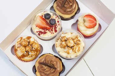 Bir kutu krem peynirli vanilyalı ve çikolatalı kek, taze çilek, ahududu, yabanmersini ve patlamış mısır süslemesi.. 