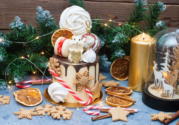 New Year cake with chocolate mouse, meringue, macaroons, candy cane, gingerbread cookies and dried oranges.