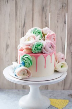 Taze çiçekler, güller, mantarlar, badem kurabiyeleri ve kremayla süslenmiş pembe eritilmiş çikolatalı beyaz pasta.. 