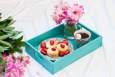 Süzme peynirli krepler, taze çilekler, şakayıklar ve bir fincan kahveyle yatakta kahvaltı.. 